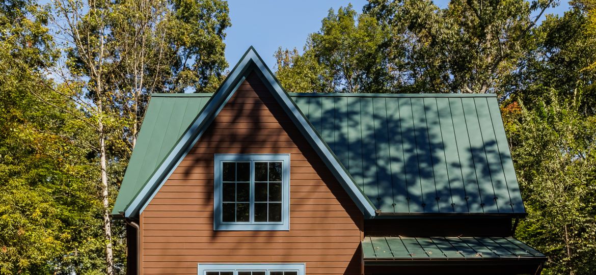 Dappled shadows from the forest around the house spread out over the facade.